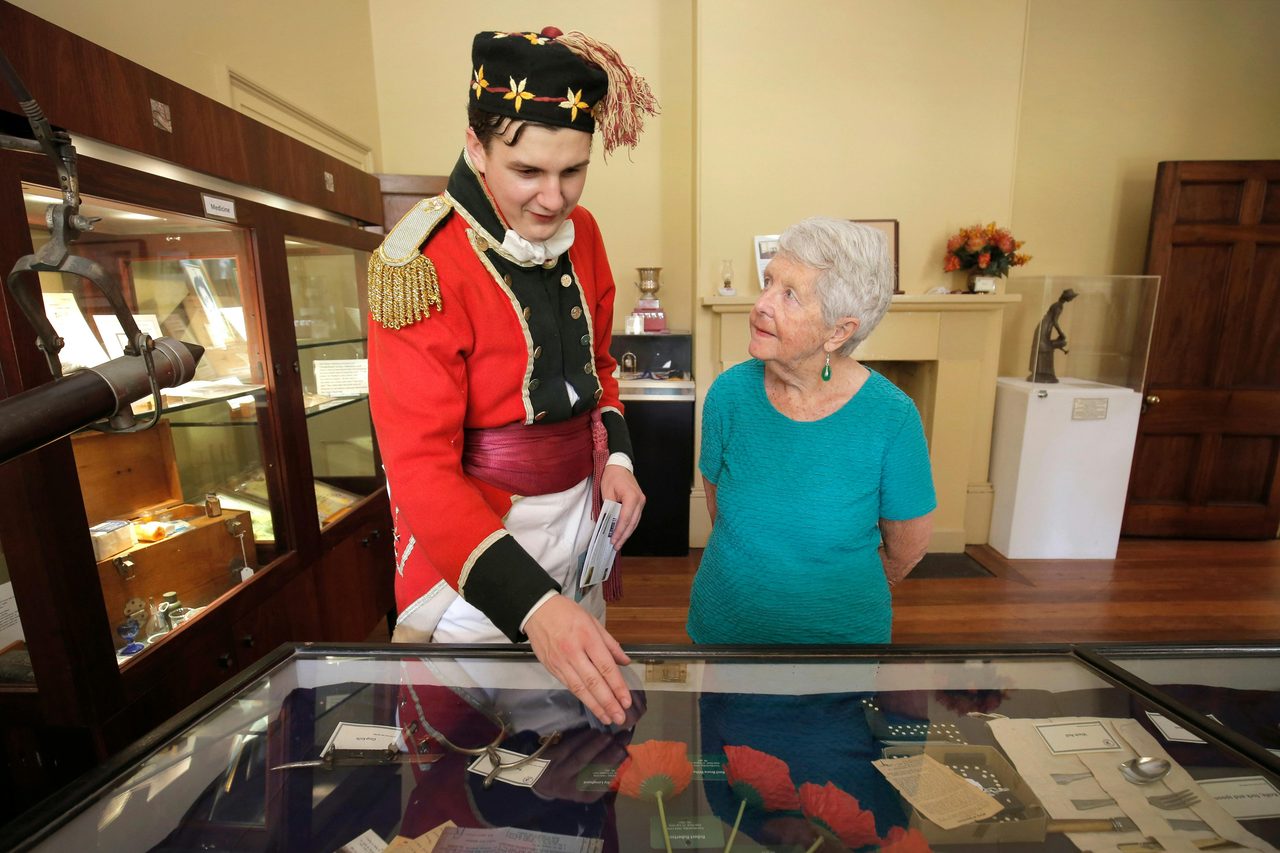 Patrons looking at museum items on guided tour