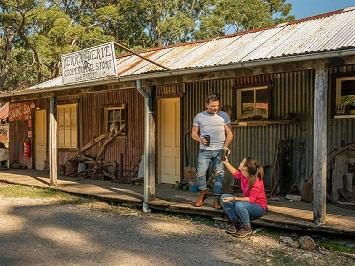 A couple drinking coffee on the verandah of The Bank Room in Yerranderie Private Town, Yerranderie