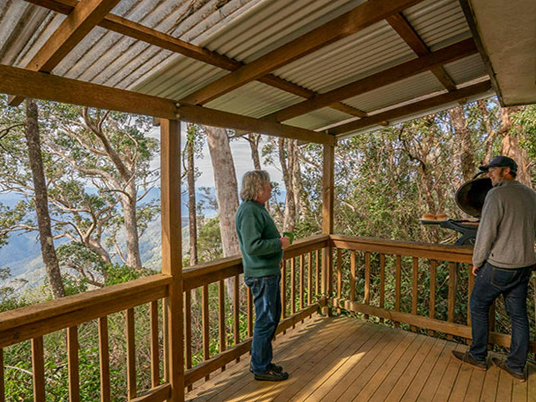 Friends barbecuing food on the balcony of The Chalet. Photo: John Spencer &copy; DPIE