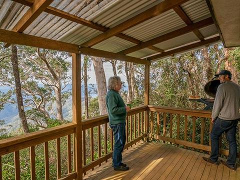 Friends barbecuing food on the balcony of The Chalet. Photo: John Spencer &copy; DPIE