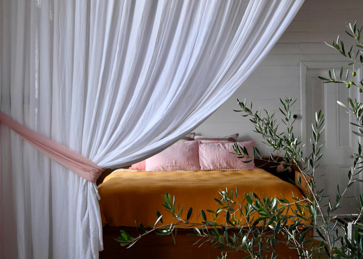 The Sweet By & By bedroom, separated by a swathe of  flax linen curtaining