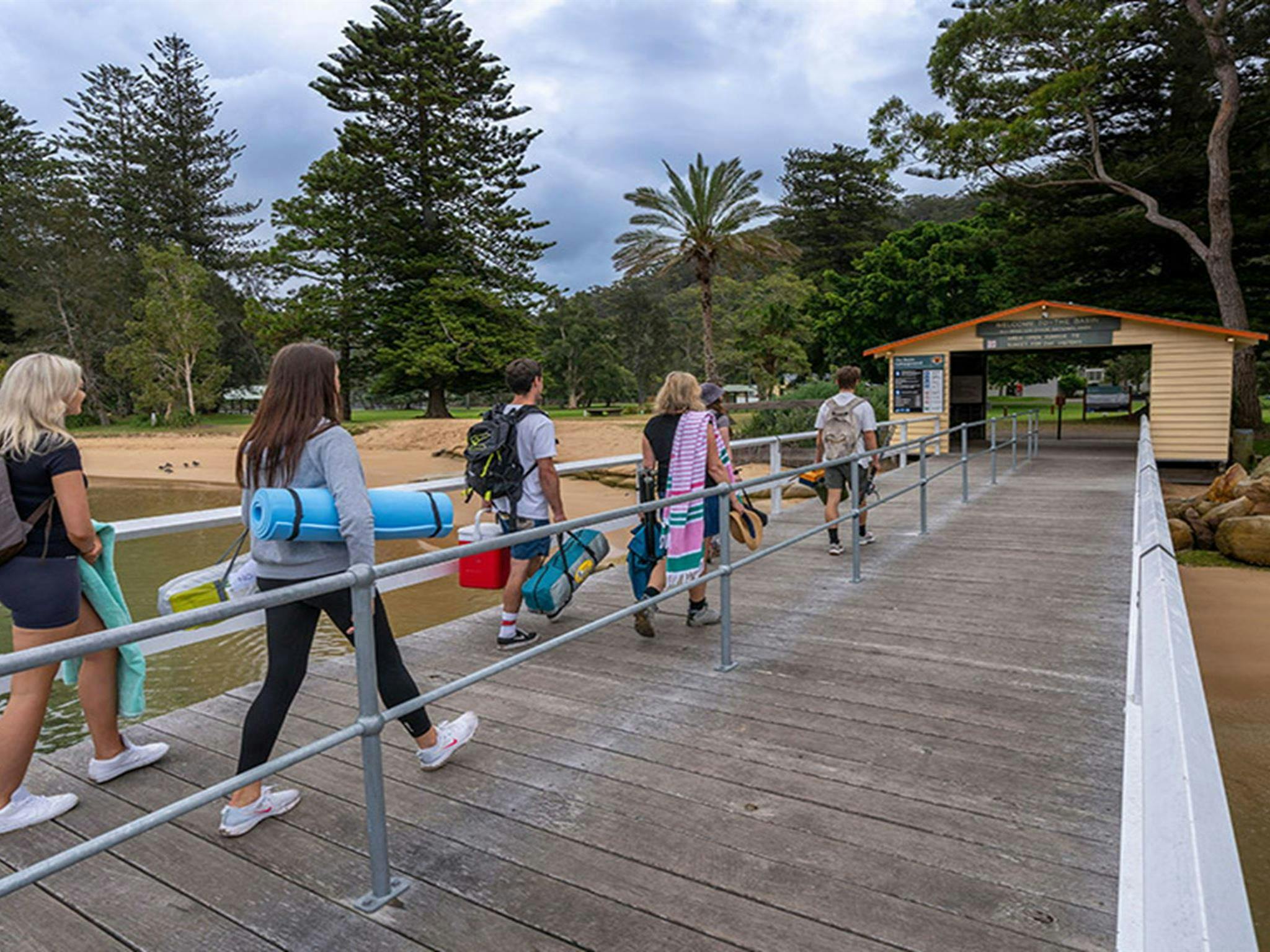 Campers walking across the ferry wharf, arriving at The Basin campground. Credit: John