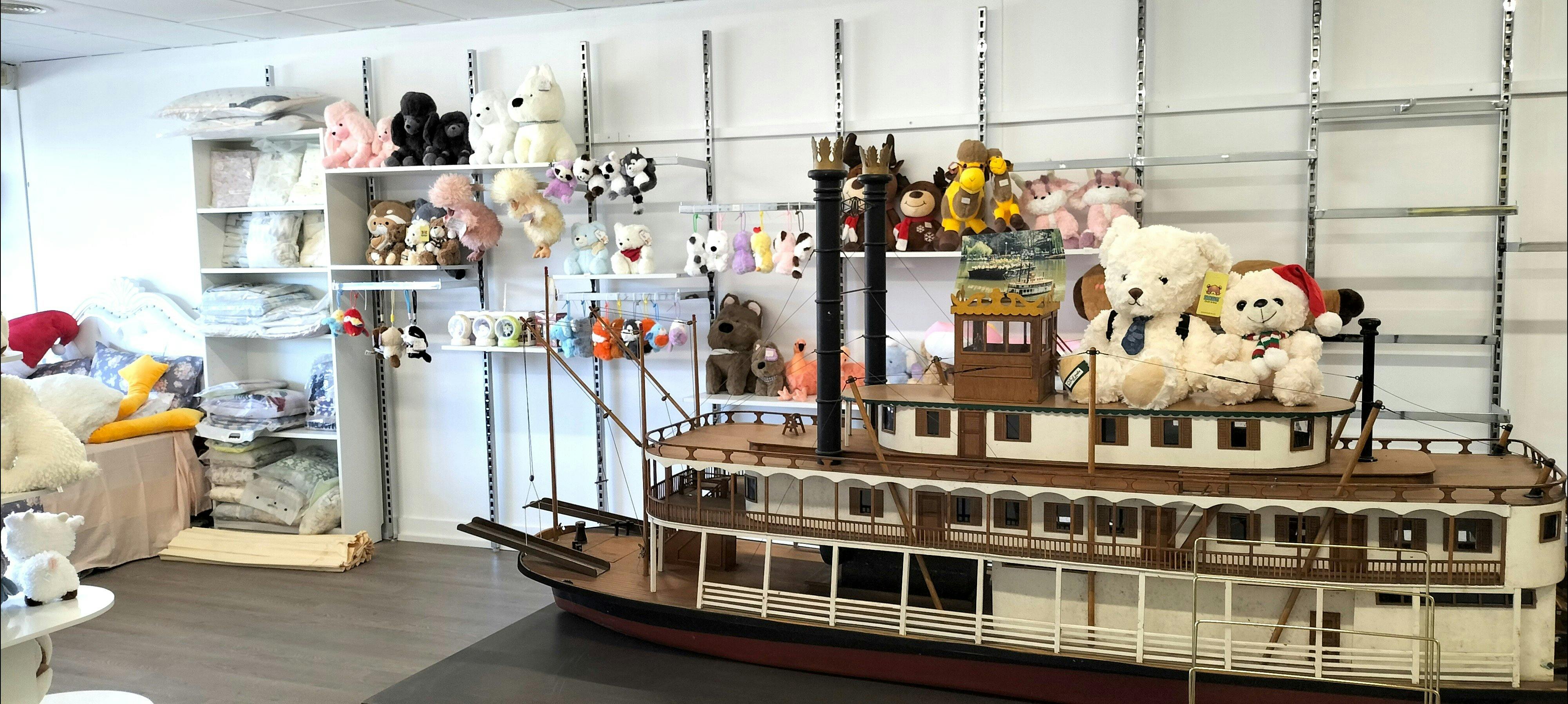 Shelves of cute animal plushies & bag charms with a large model boat as the shops' centrepiece.