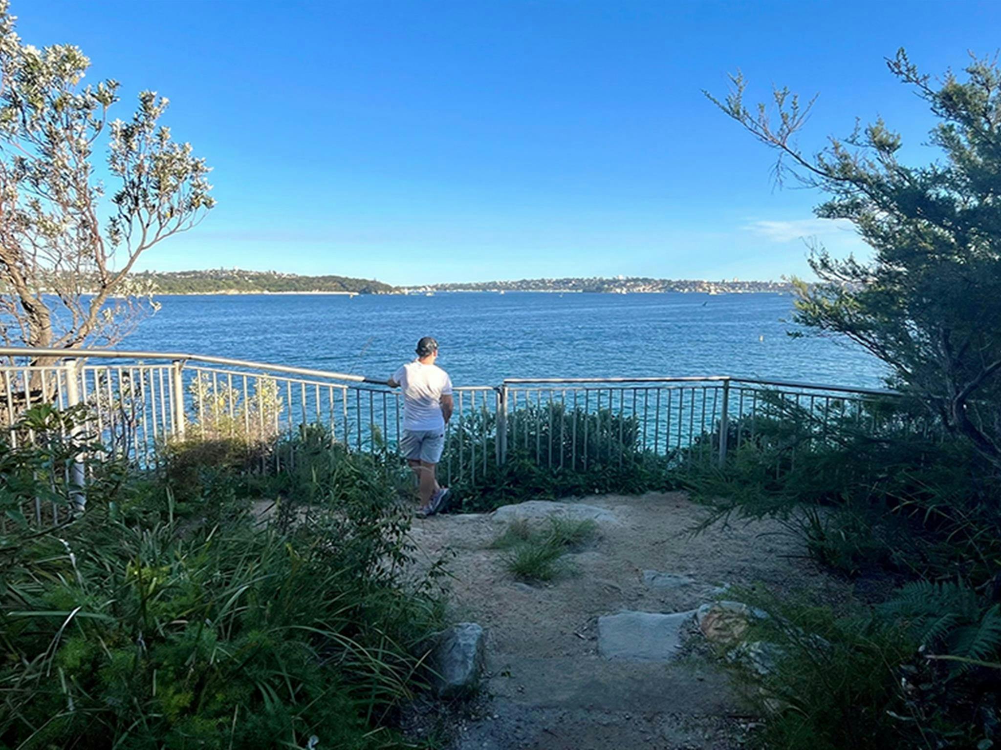 Man surveys the harbour view from a small lookout at Georges Head, one of several in this area.