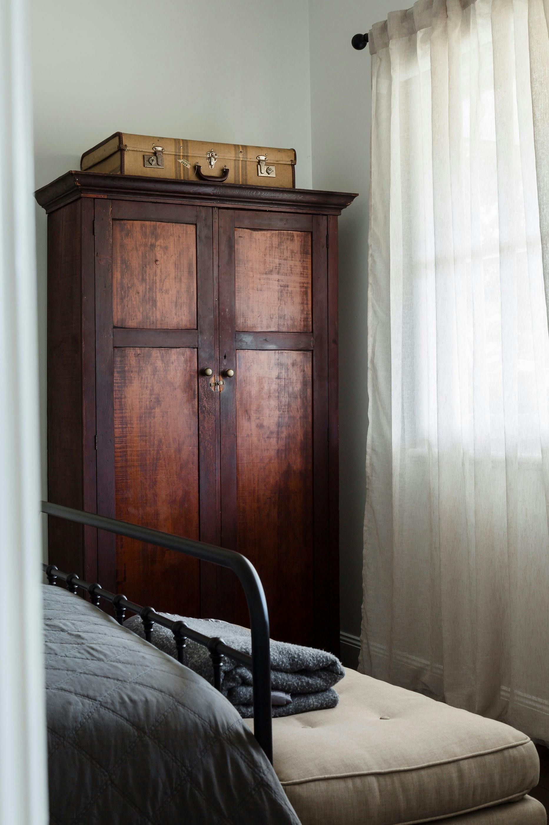 Beautiful queen guest room with antique wardrobe