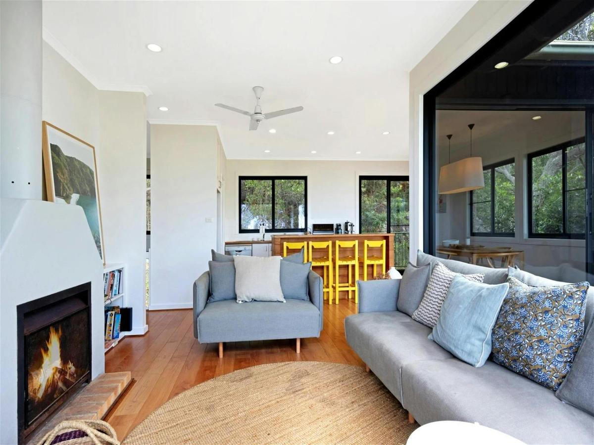 Open plan living, dining and kitchen area, with high ceilings and floor-to-ceiling light