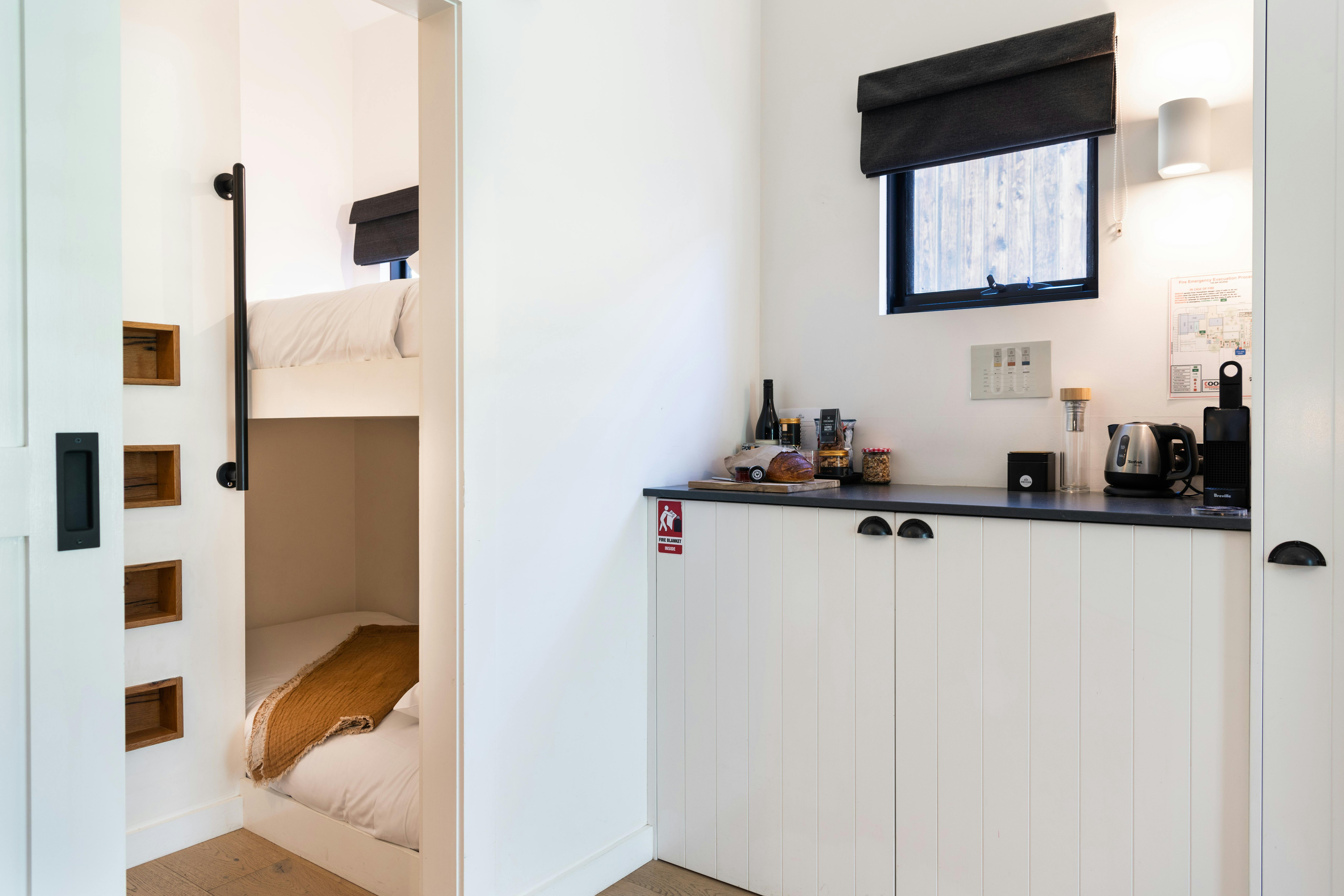 Kitchenette to the right and an open door to the left showing a cosy bunk bed room