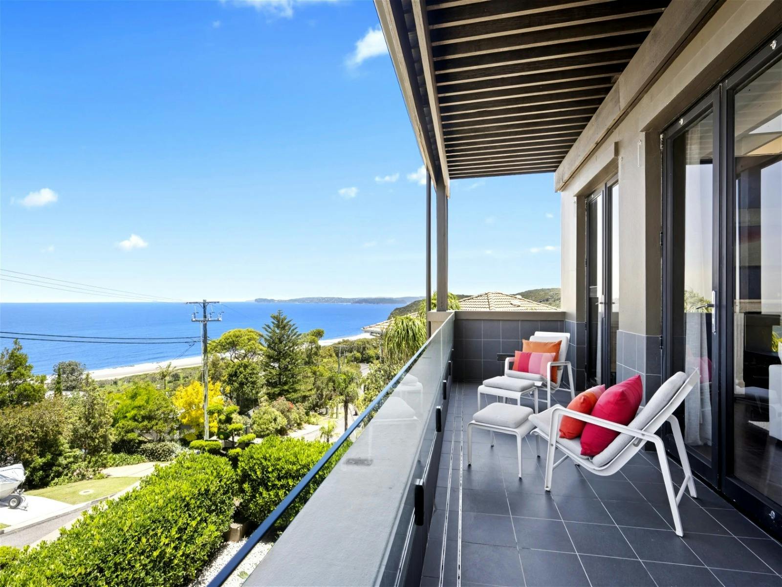 Open-plan living spaces flowing to a covered waterfront deck with barbecue