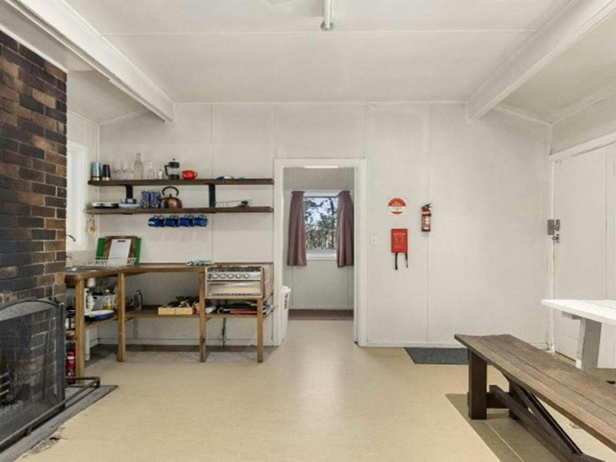 The interior of Toms Cabin with table, benches, fireplace and gas kitchen in New England National