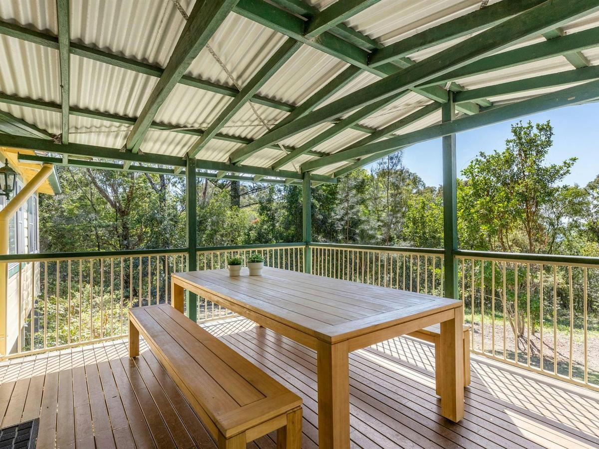 The verandah with outdoor table and benches at Tuckers Rocks Cottage in Bongil Bongil National Park.