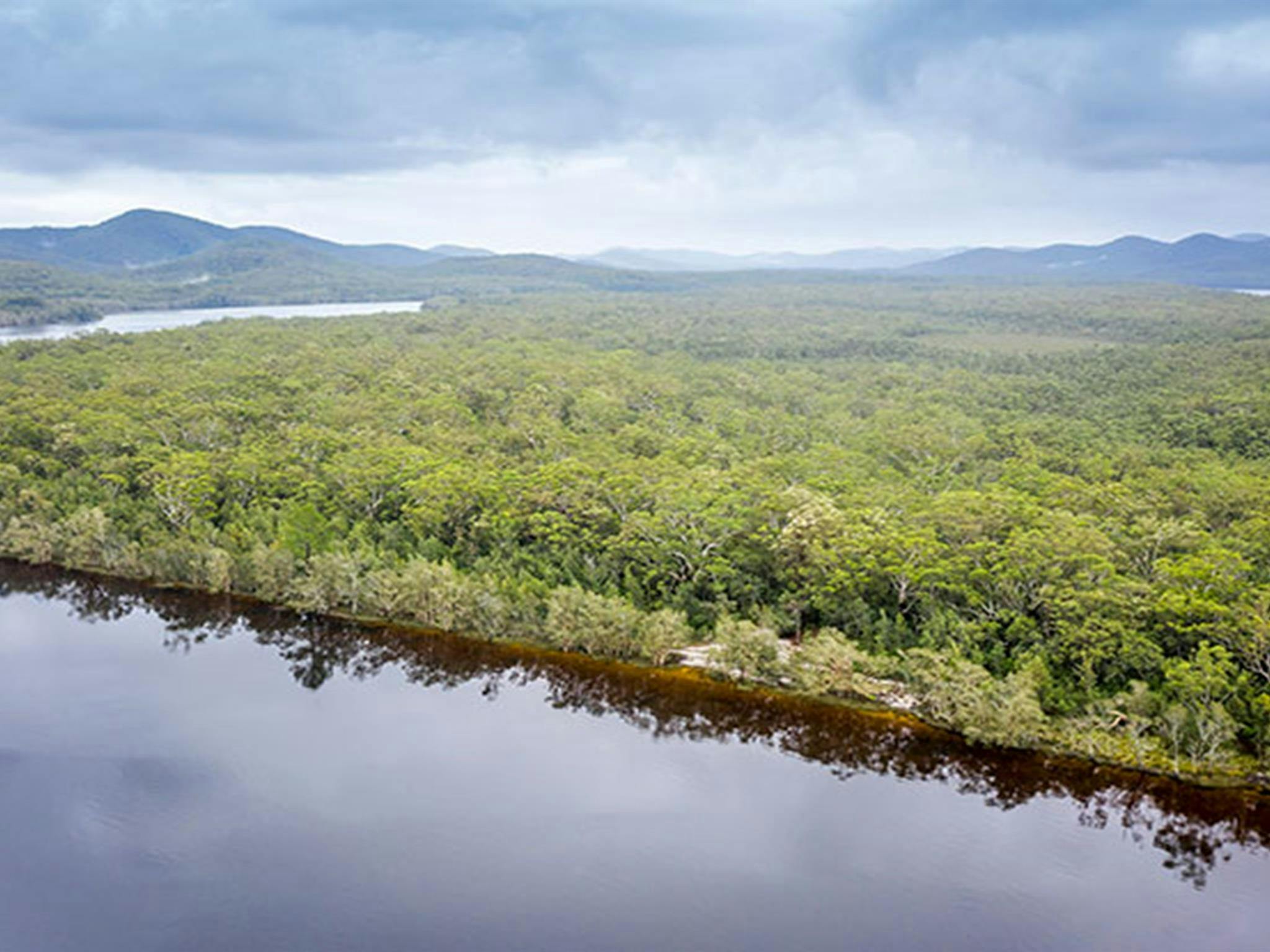 Aerial view of remote Two Mile Sands campground with surrounding bushland and waterways in Myall