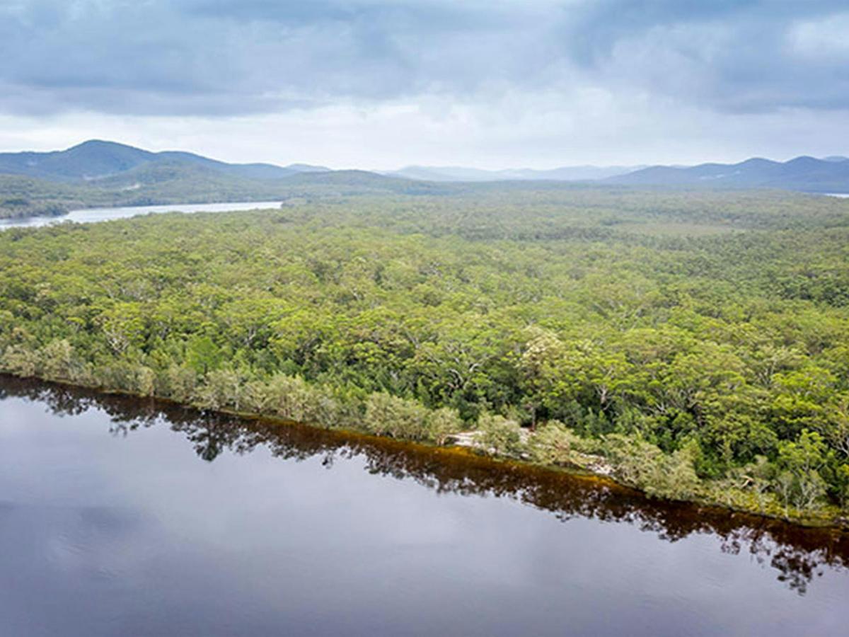 Aerial view of remote Two Mile Sands campground with surrounding bushland and waterways in Myall