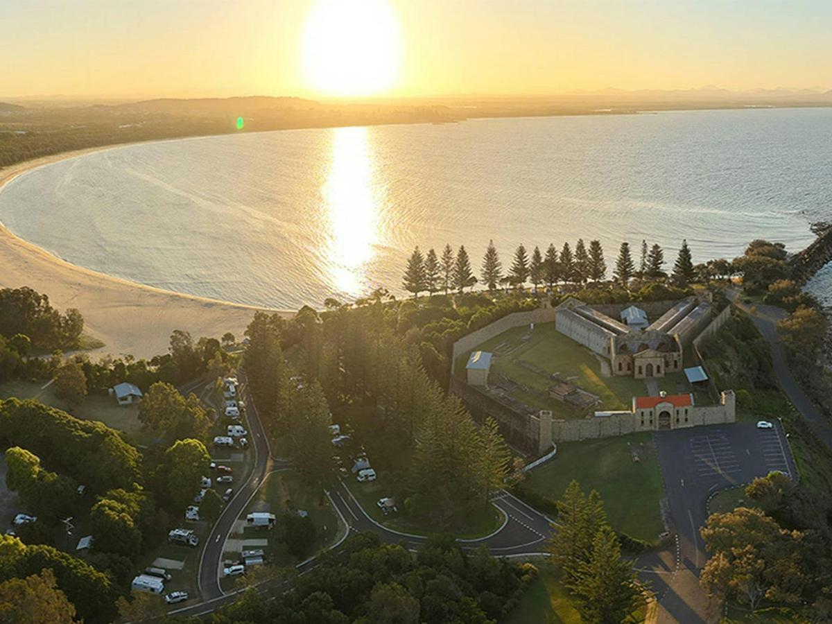 Aerial view of Trial Bay Gaol campground and the ocean at sunset. Credit: Glen Ellis &copy; DCCEEW