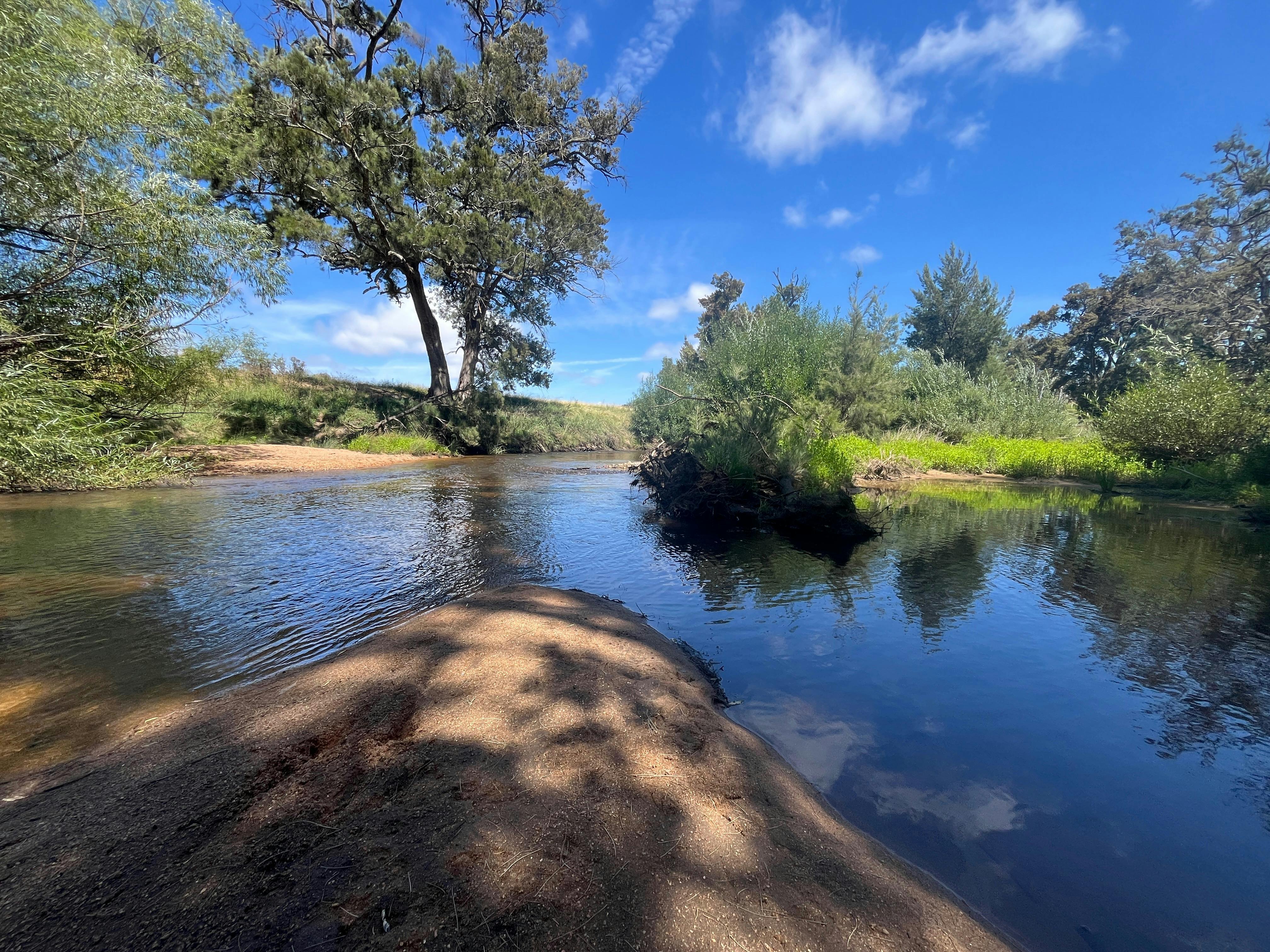 A sandy peninsula, bright blue sky, crystal clear water