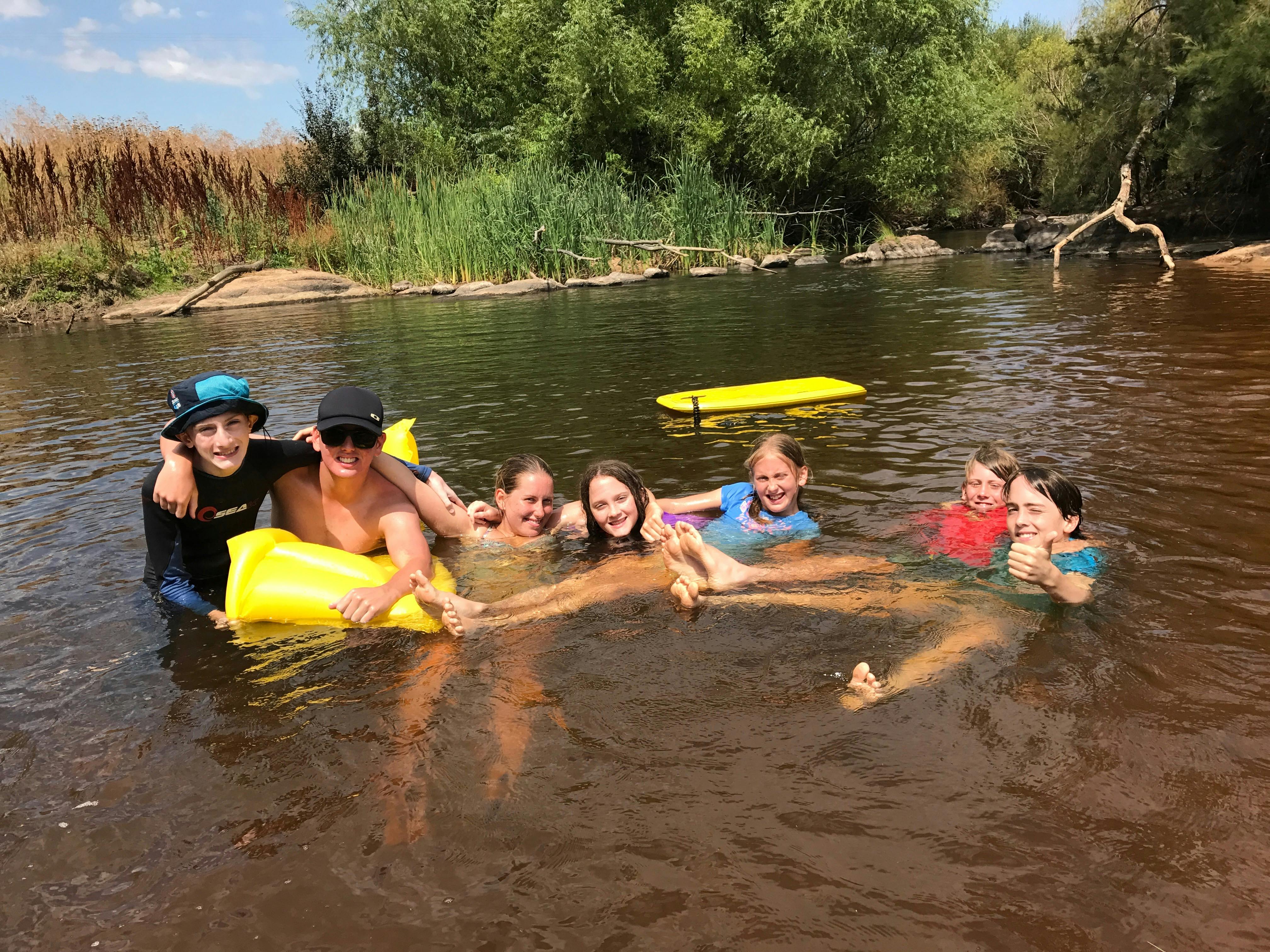 Kids having fun in one of the deeper water holes with fun swimming toys
