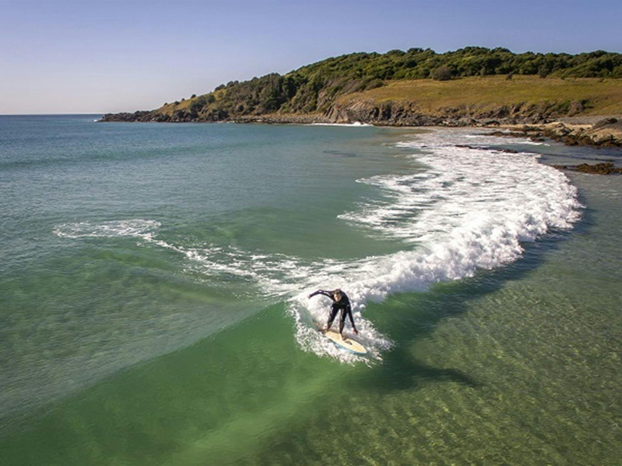 A man surfing a wave back to the shore at Goolawah National Park. Photo: John Spencer/OEH