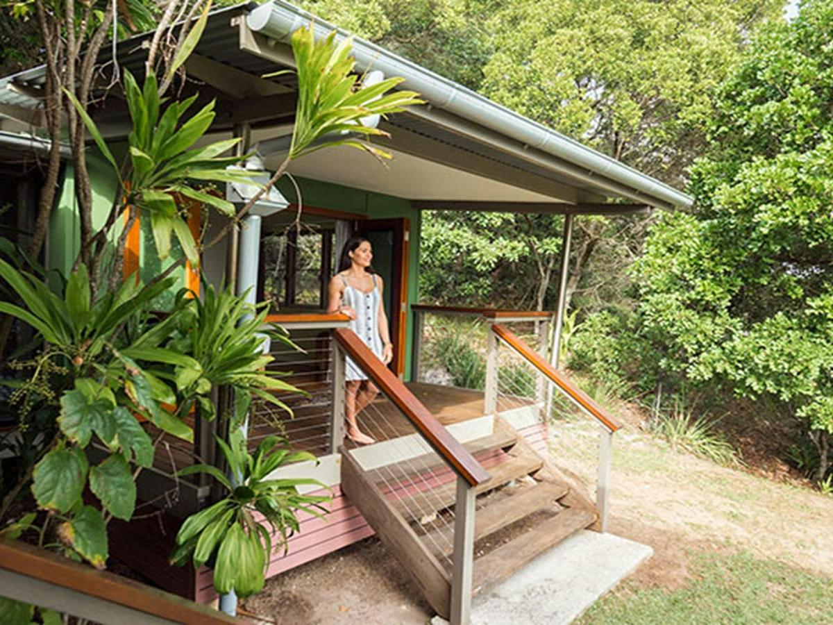 Woman walking out of her bedroom into the secluded bush at Thomson Cottage. Photo: Sera Wright/DPIE