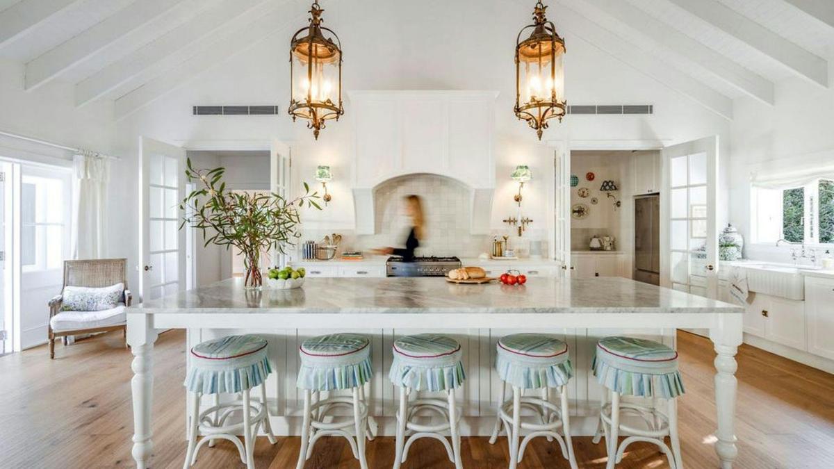 A generous kitchen with its oversized island bench to the alfresco dining area beside the pizza oven