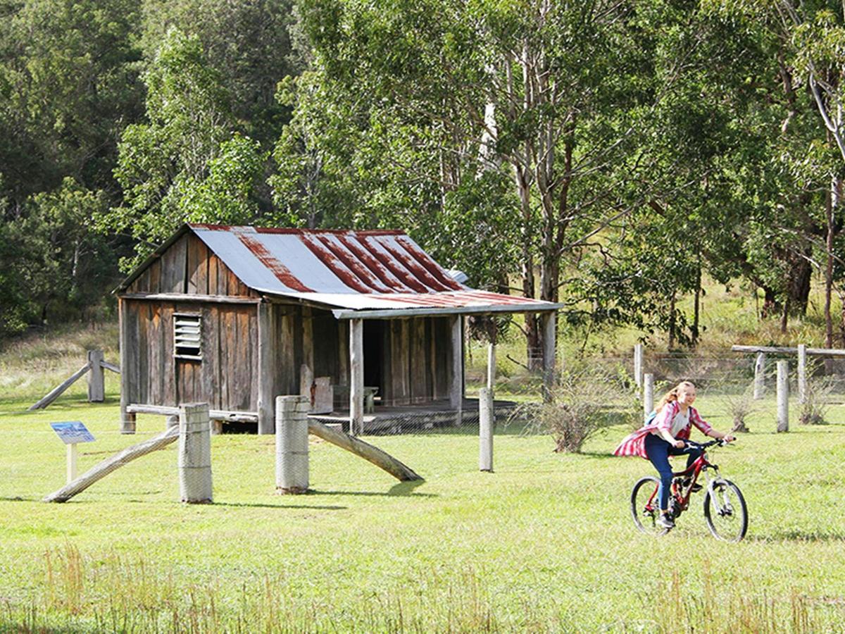 Girl rides a mountain bike on the campground next to historic Youdales Hut. Credit: Natasha Webb
