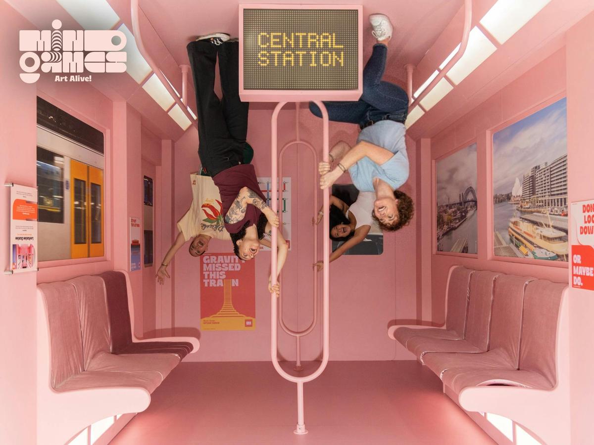 Guests explore the Upside Down Train installation at Mind Games | Art Alive in Sydney.