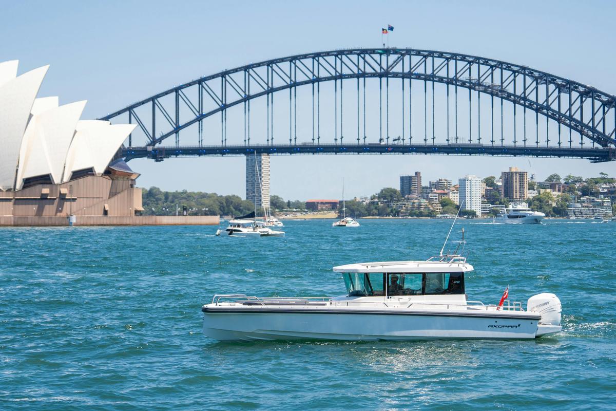 Luxury motor yacht cruising on Sydney Harbour with city skyline in the background