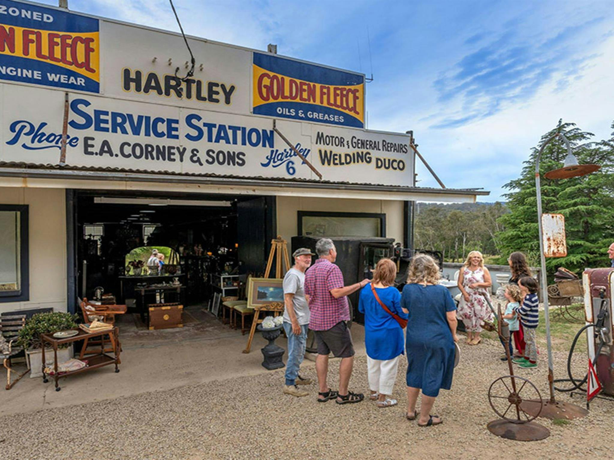 Visitors outside the antique shop in Corneys Garage, Hartley Historic Site, near Lithgow. Credit: