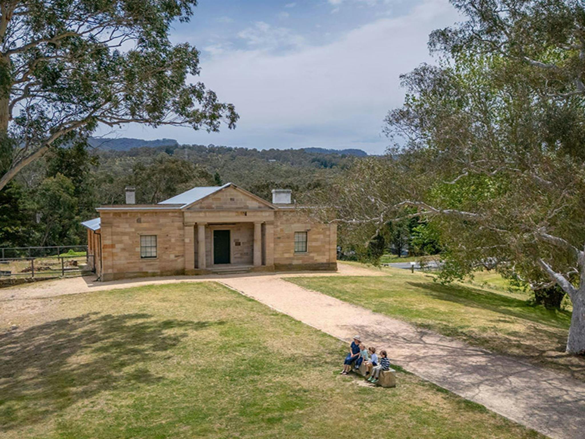 An aerial image of people sitting outside Hartley Courthouse at Hartley Historic Site. Credit: John