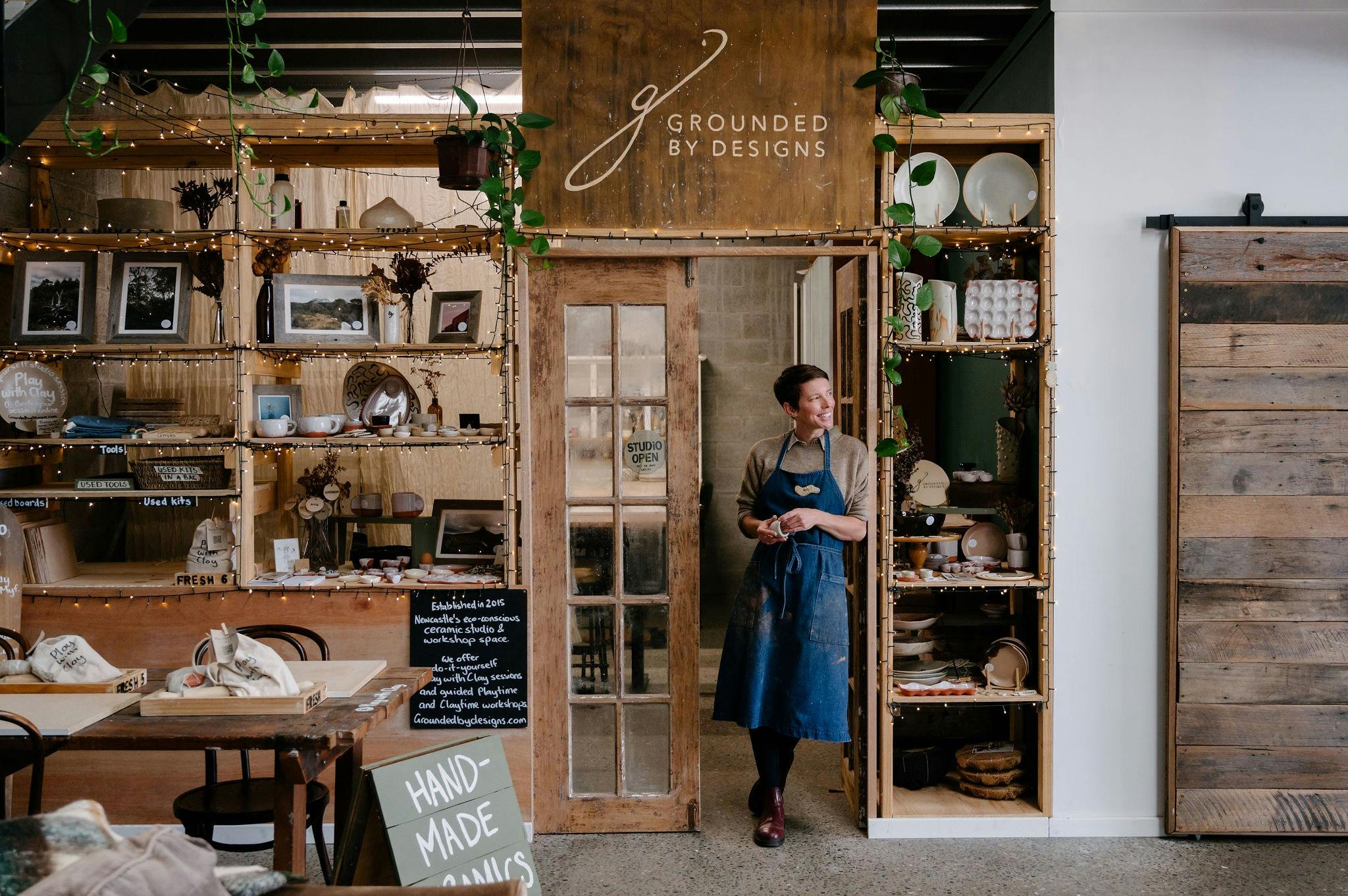 Myf Garven leaning on the doorway to her studio, Grounded By Designs