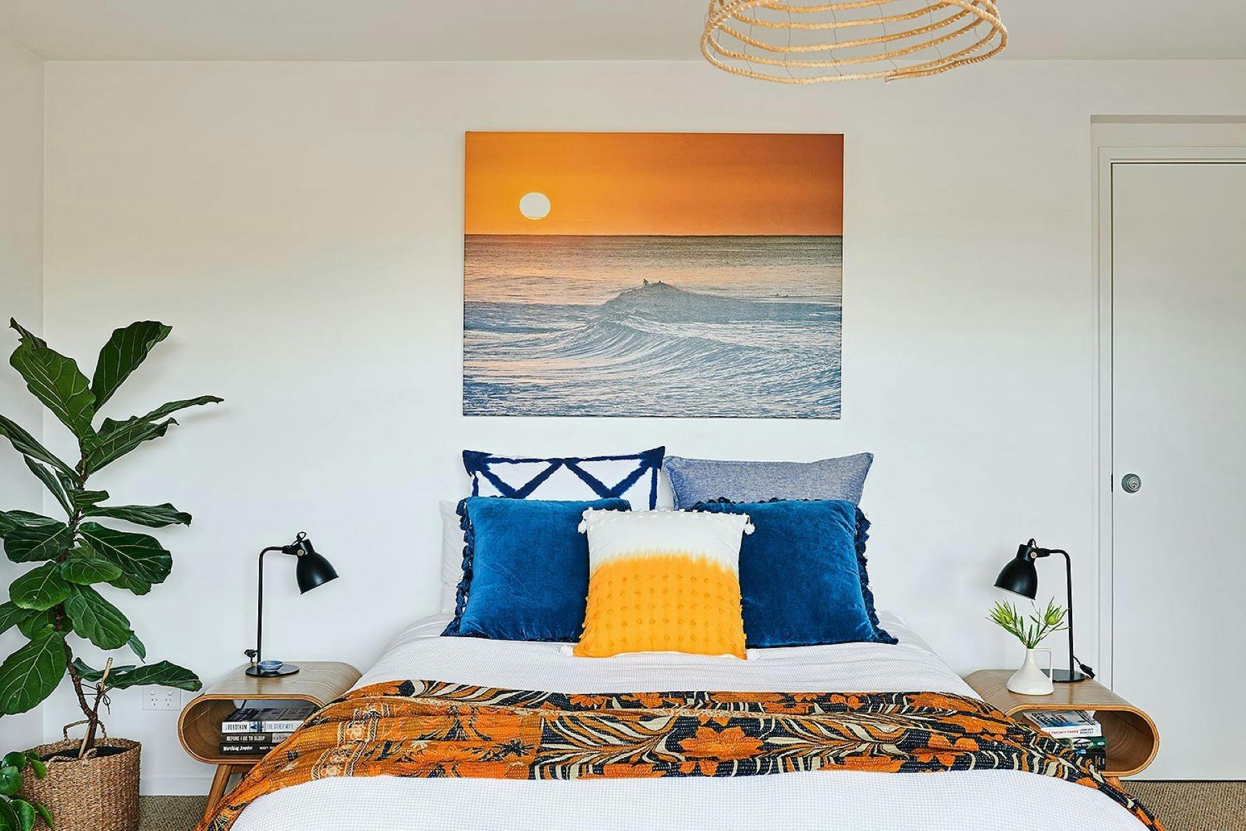 Bedroom with picture of beach with sunset.
