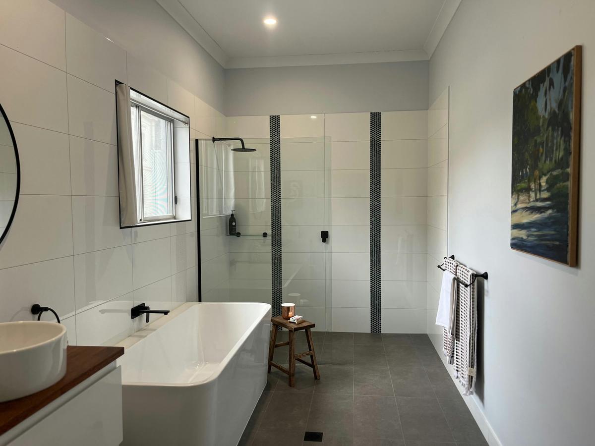 Spacious bathroom with personal amentities, first aid kit, walk in shower and large bath.
