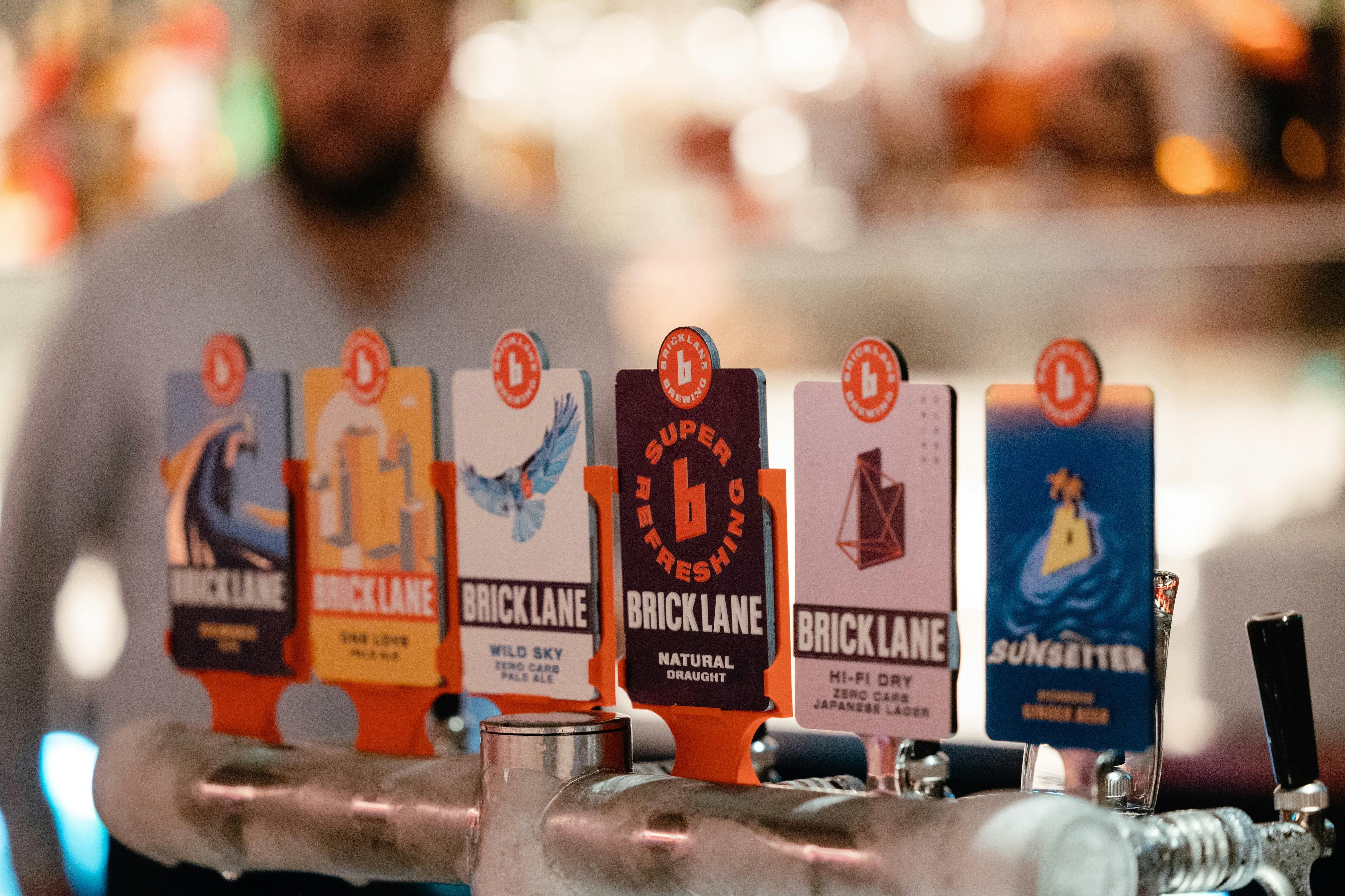 a line up of beer tap decals featuring brick lane beers in the bar