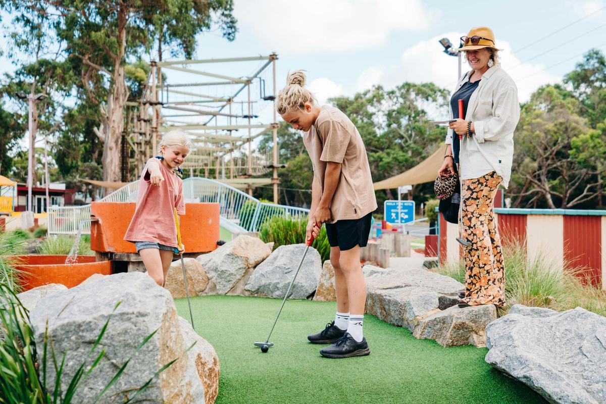 Family playing the 19 hole mini golf course at A Maze'N Things