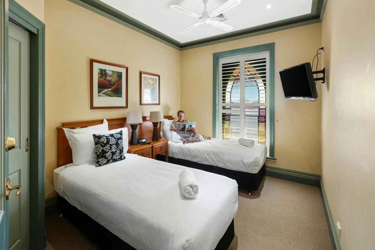Guest relaxing on bed in three bedroom apartment