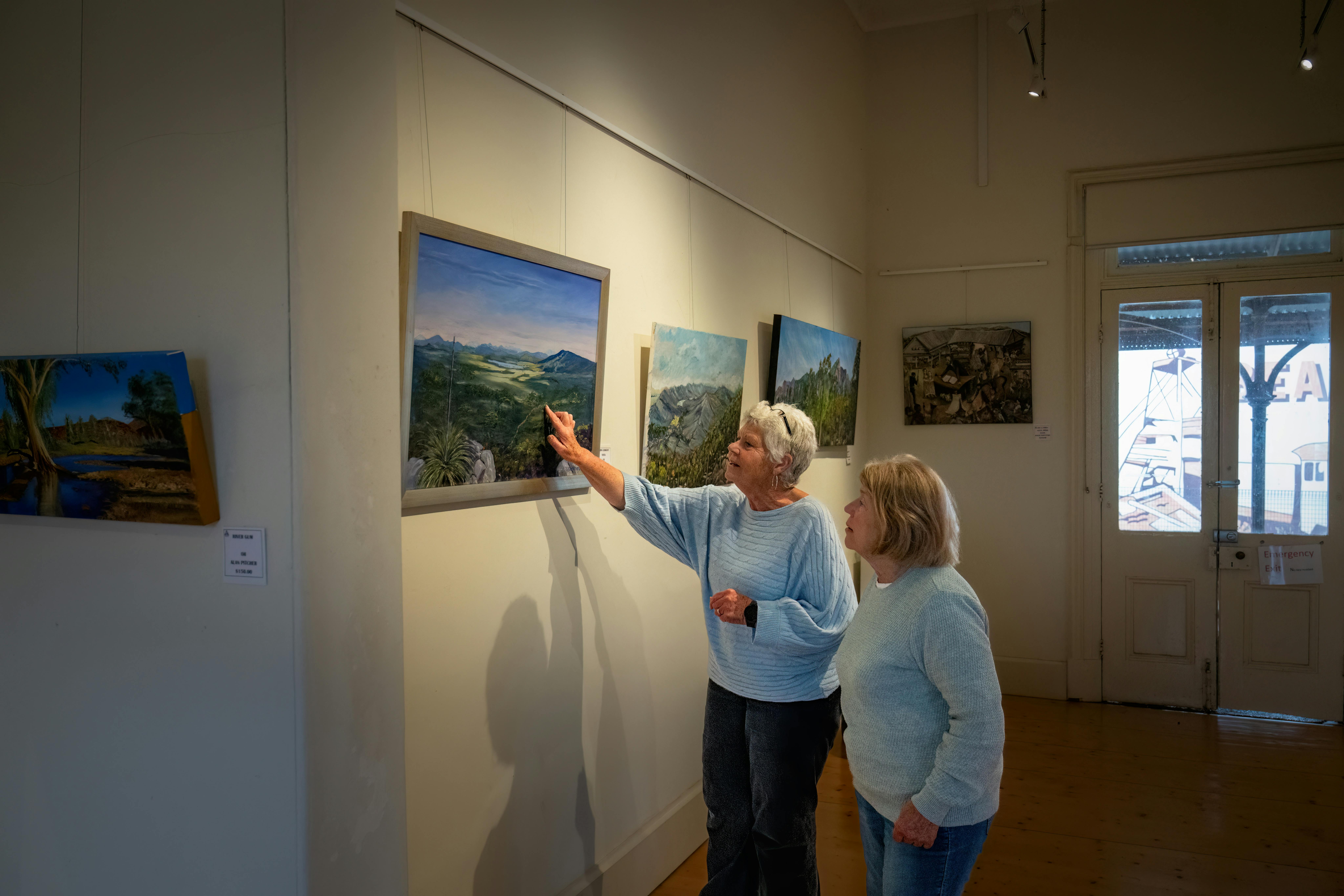 Two women looking at art work