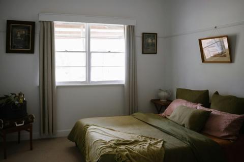 double bed inside a room with windows and picture frames on walls