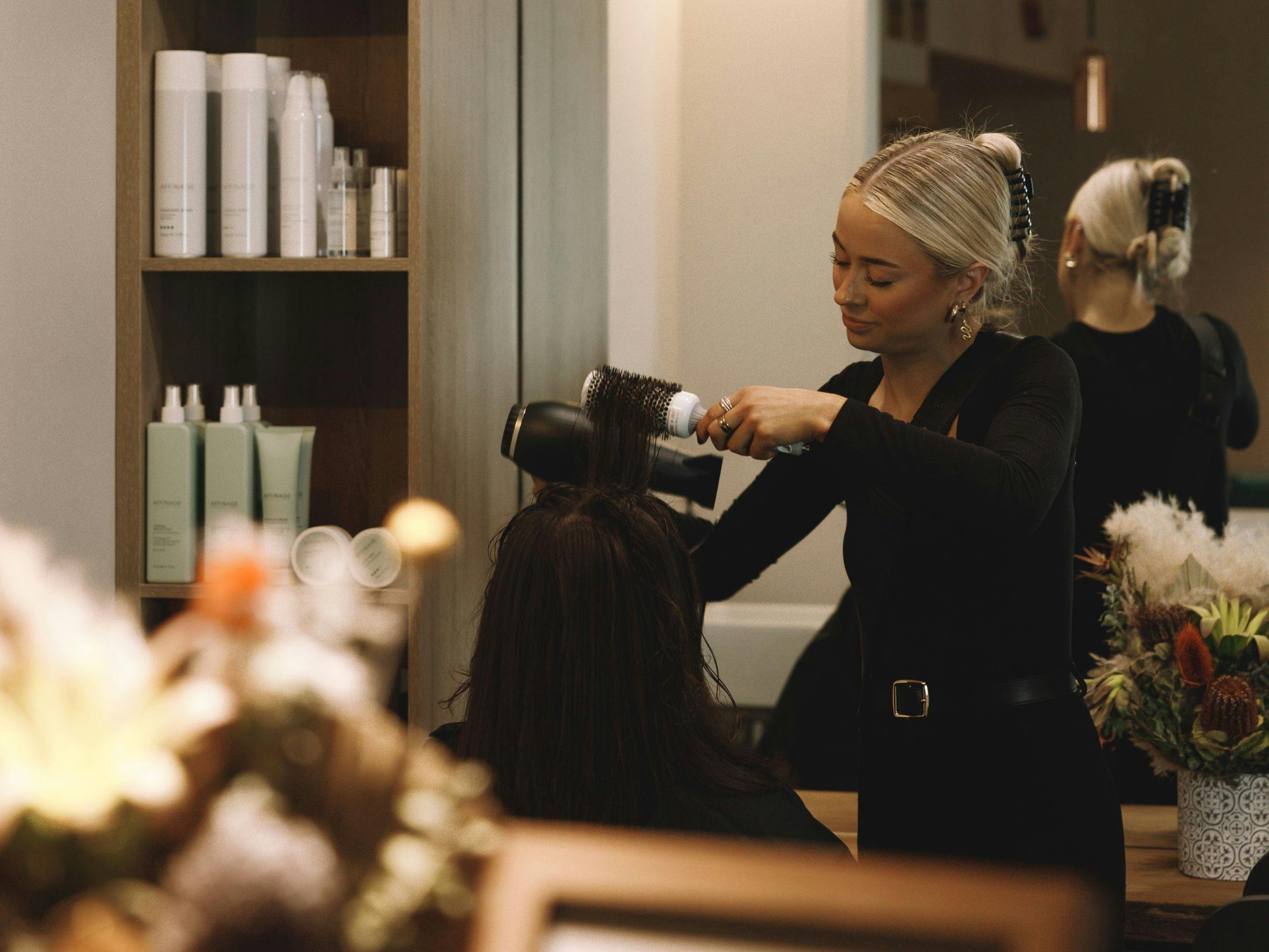 An image of the Astra in house hairdresser performing a blow wave on a client