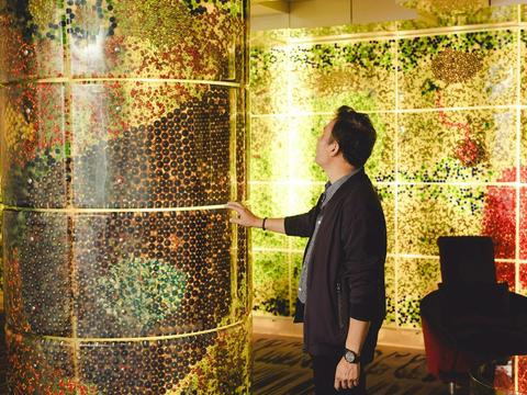 Person touching a pillar in a very colourful room.