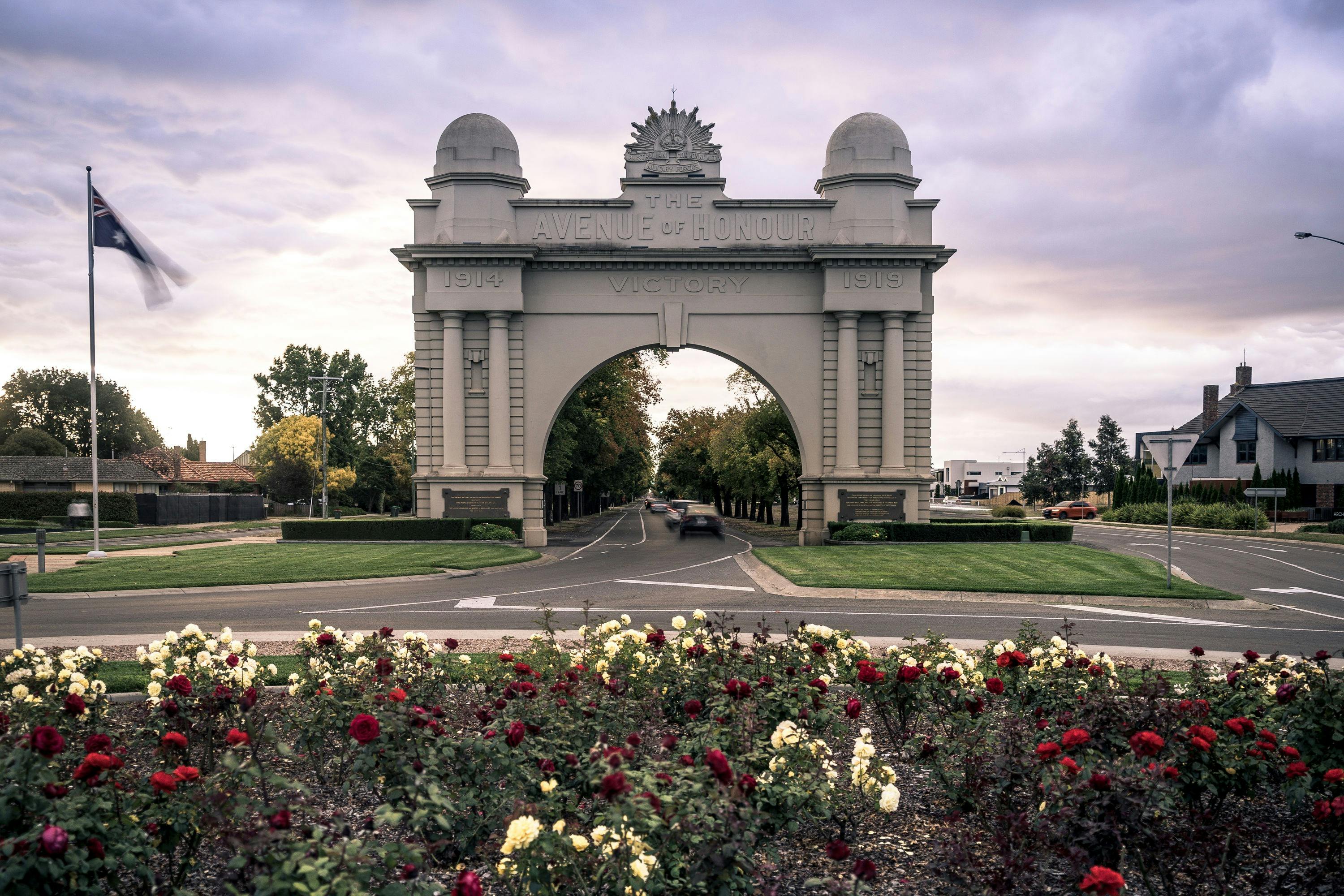 Front view of the Arch of Victory, with cars driving though