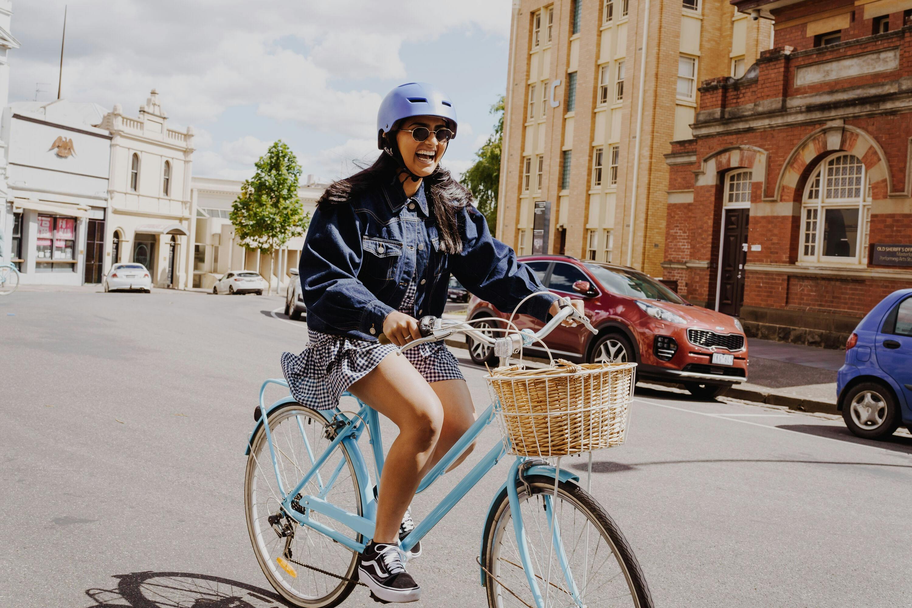 a lady rides through a Ballarat street on a bike