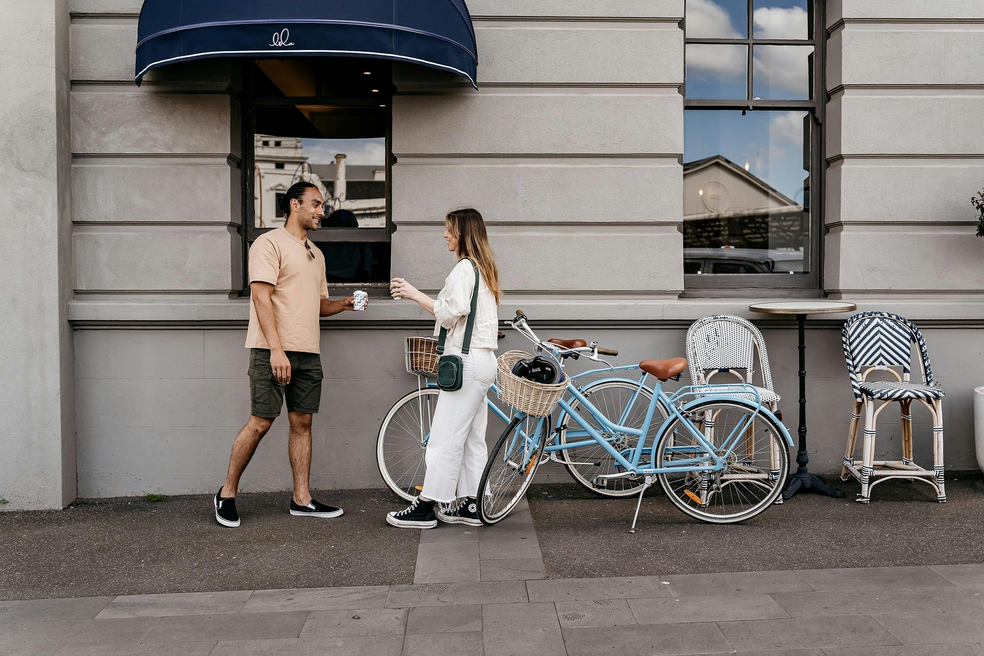 two people order a coffee next to their bikes