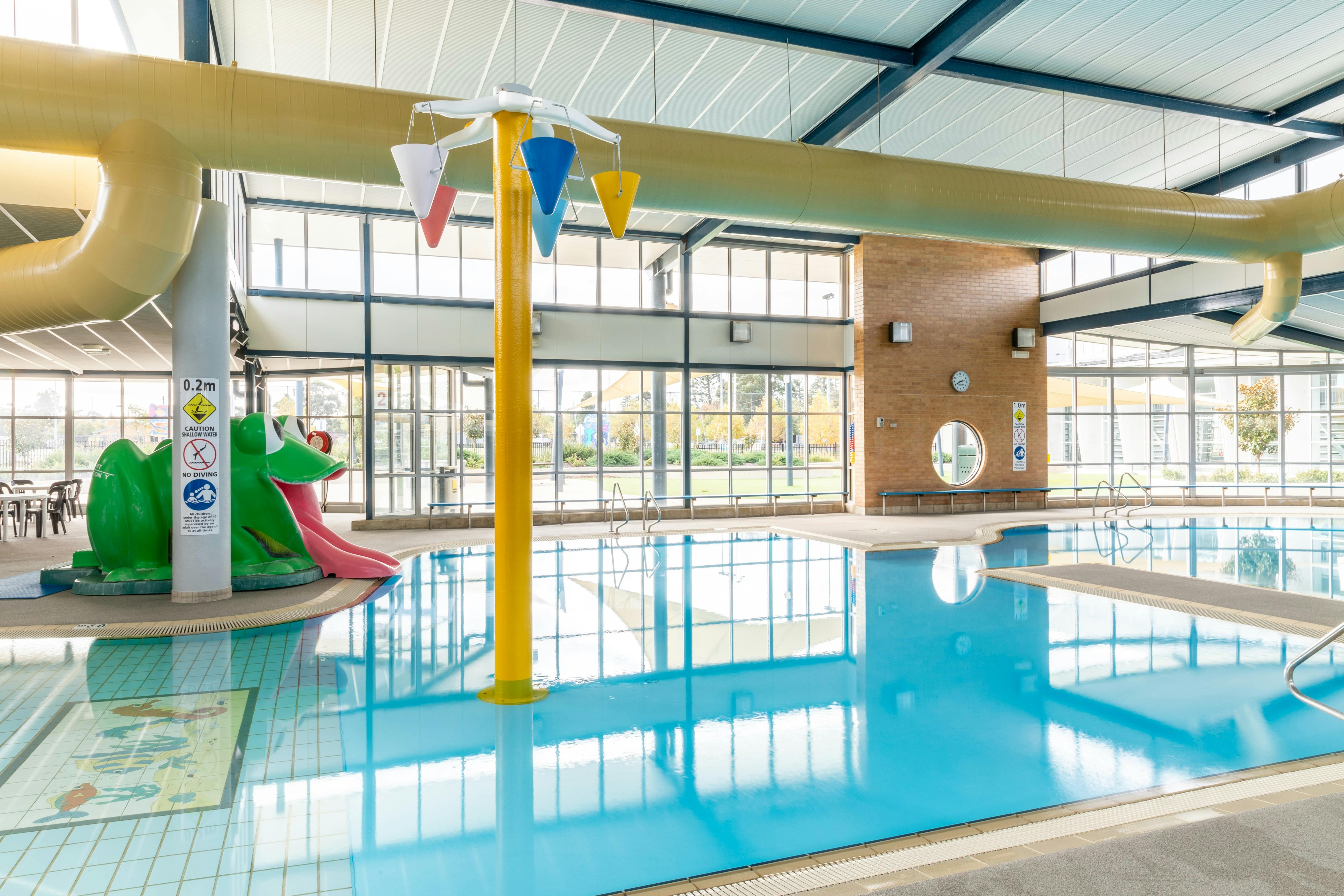 Learn to swim pool, with a green frog slide, and a yellow pole with buckets