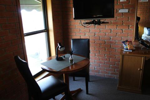 twin room with two seat table and television