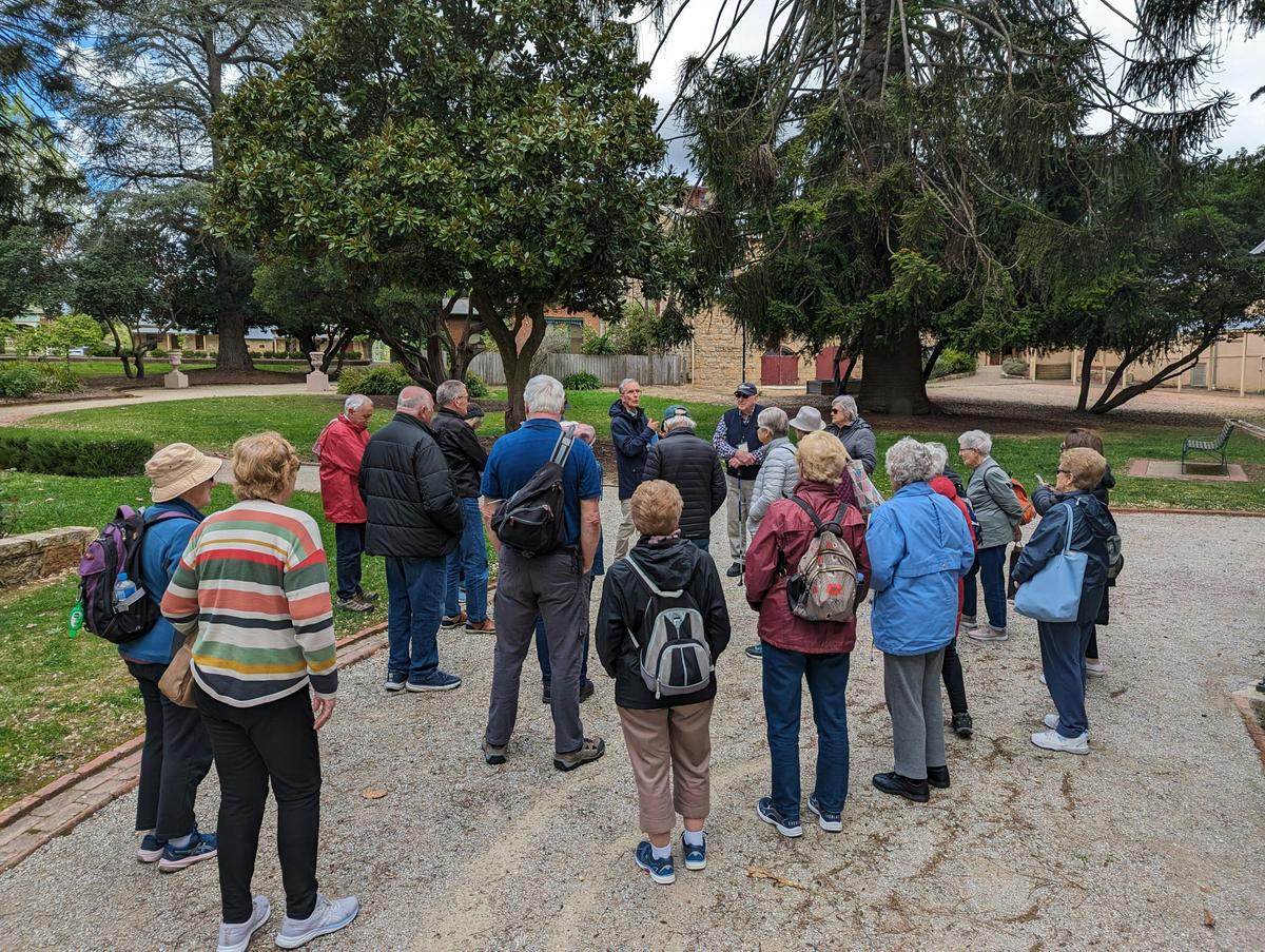 Group of people listening to a tour guide overlooking the botanic garden