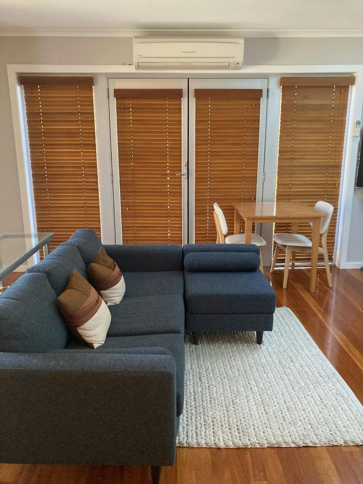 grey sofa with white rug on hardwood floors