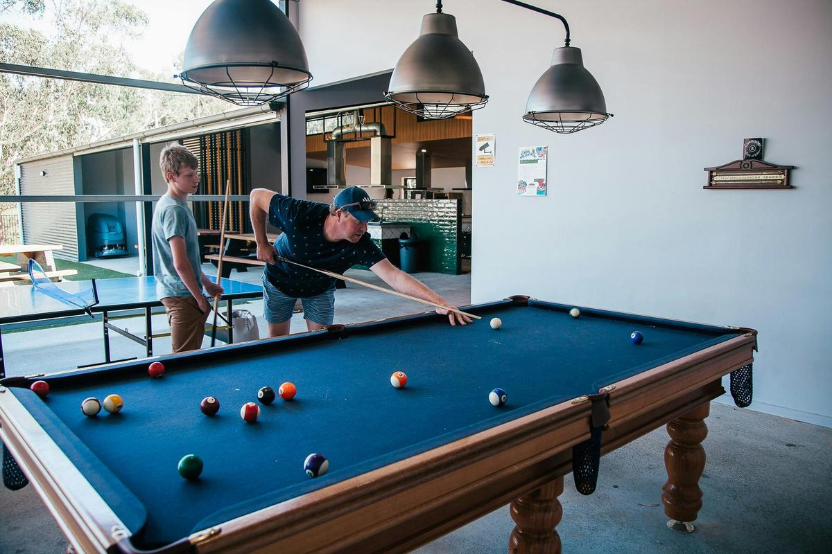Father and son playing pool in the camp kitchen