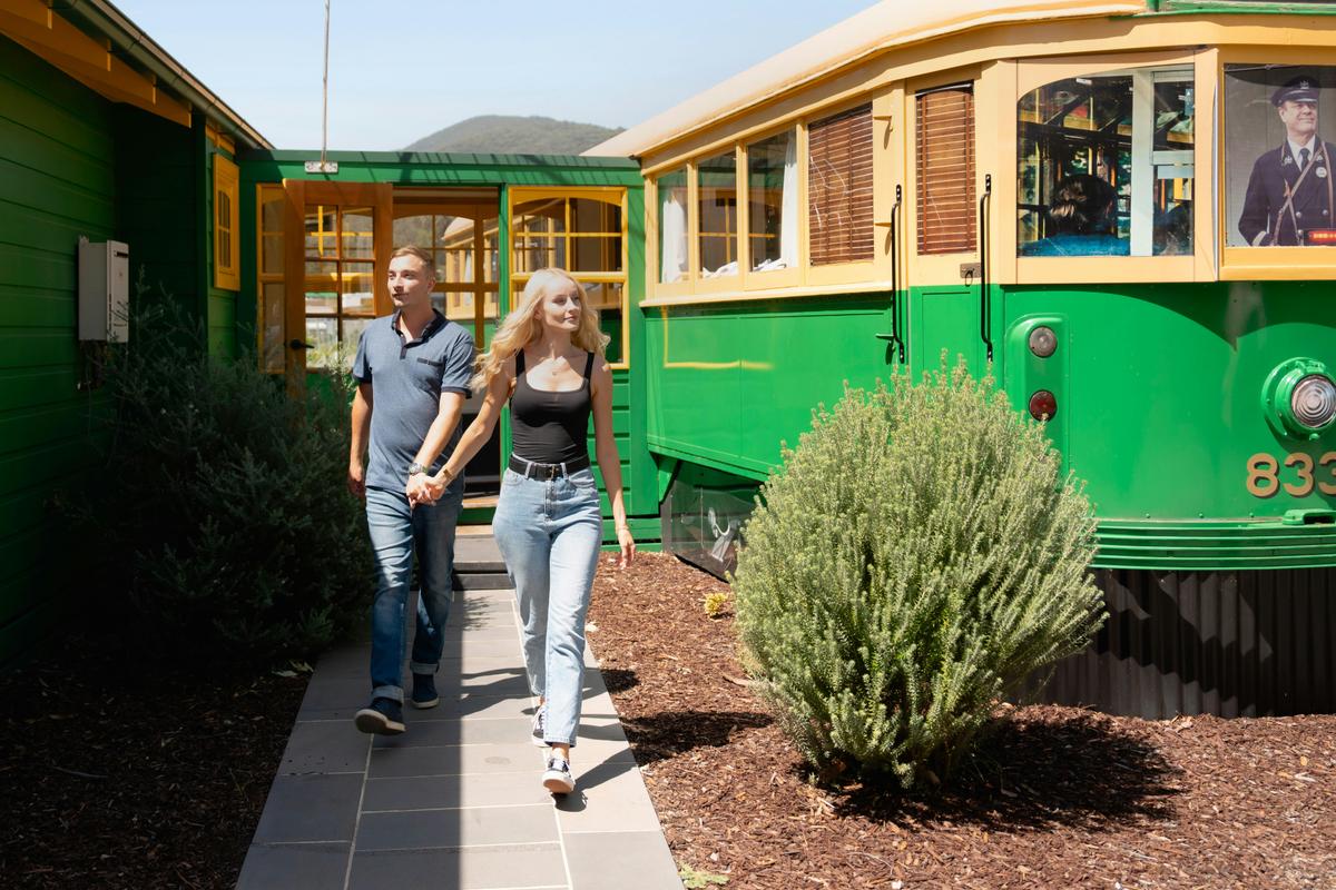 Couple walking out of the unique Melbourne Tram accommodation