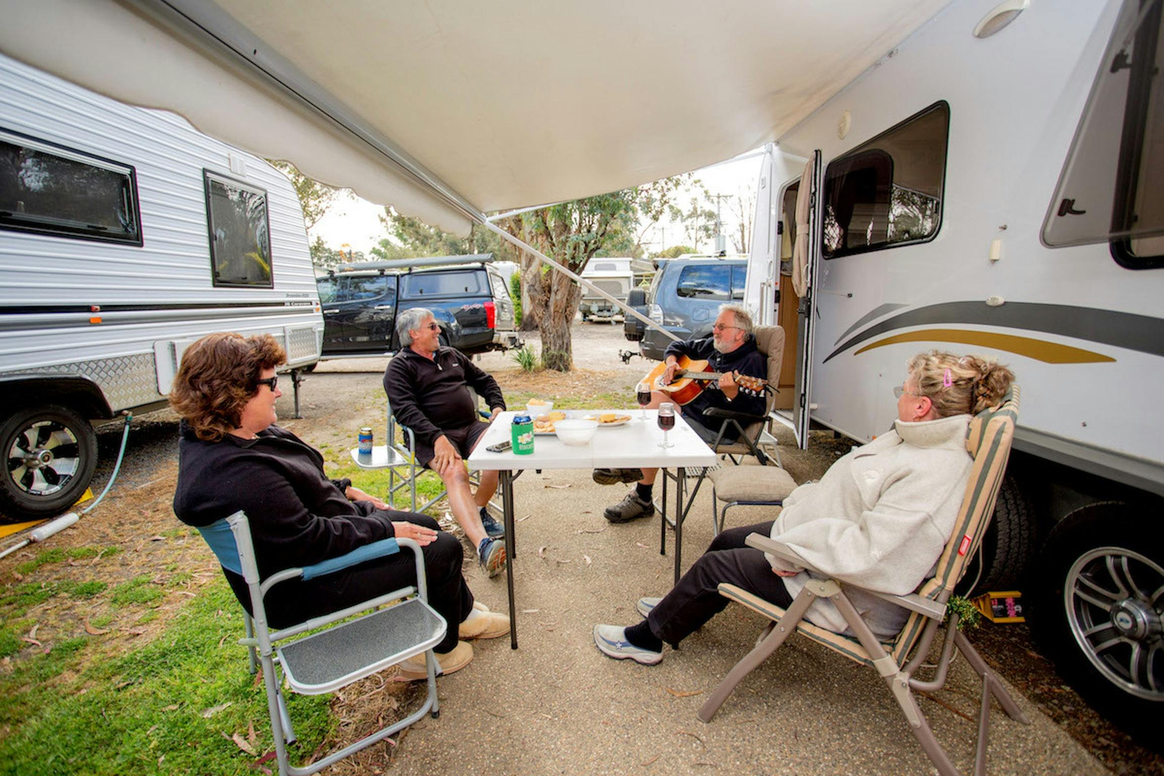 Friends relaxing outside their caravan