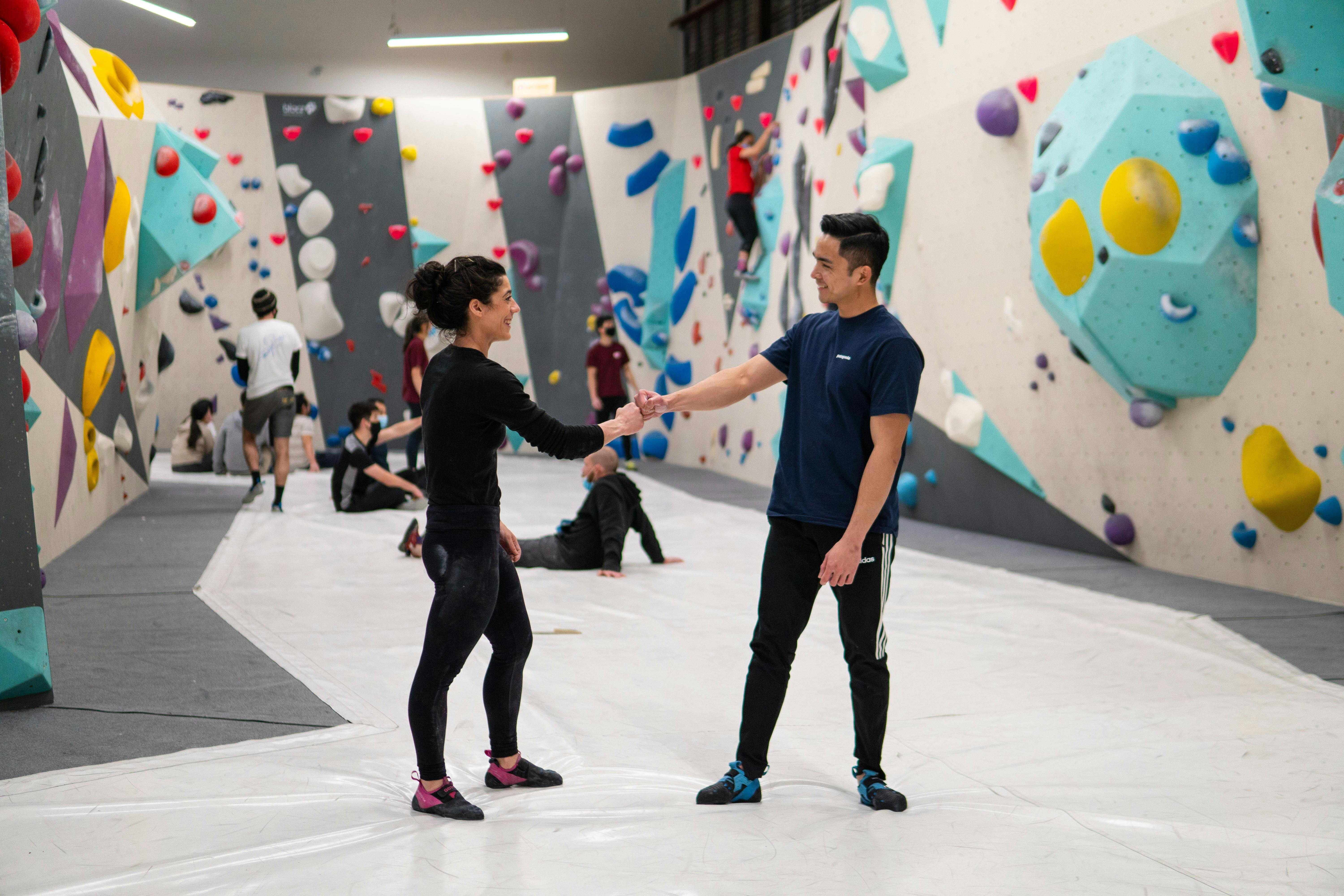 Two climbers giving each other fist bumps.