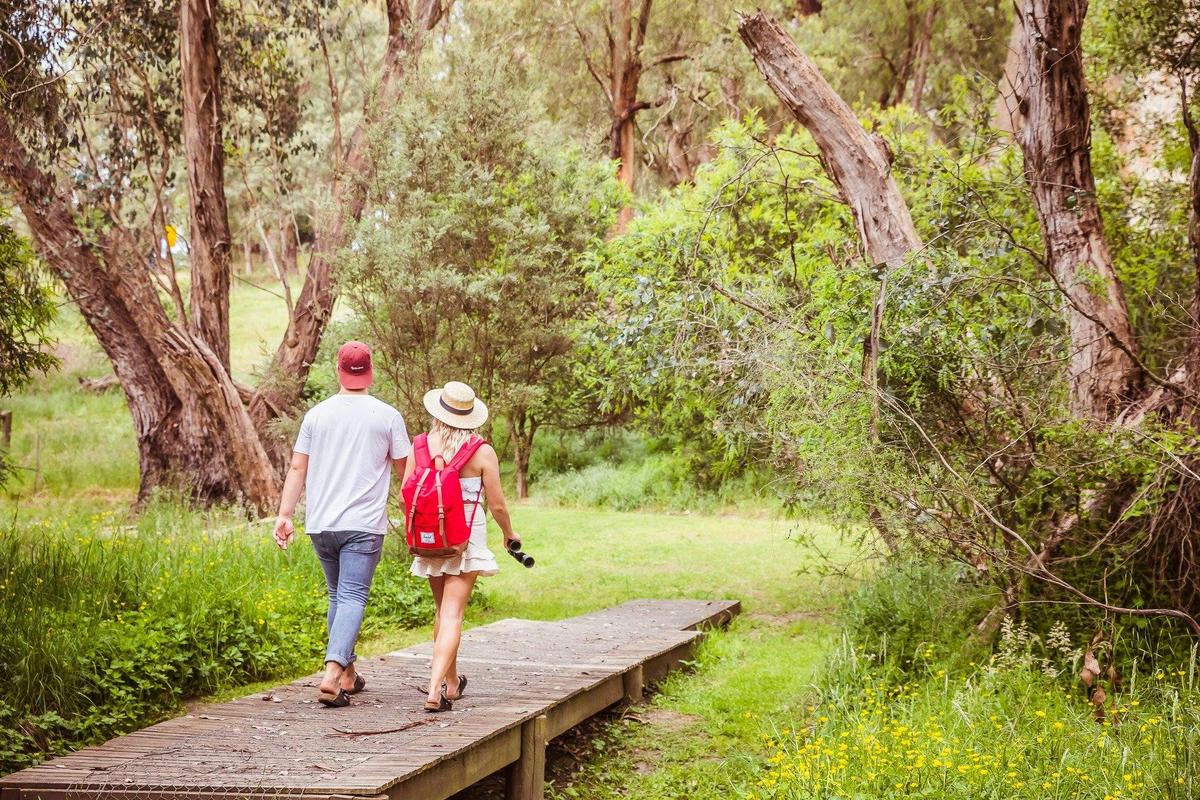 Couple walking across wooden bridge