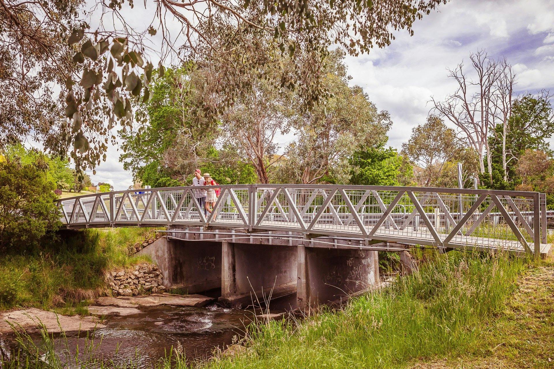 People looking at waterway from bridge